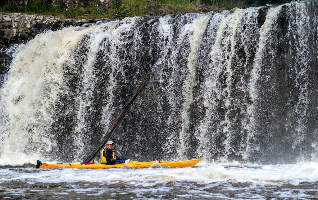 A kayaker in front of the Haruru Falls, one of the emblematic places to discover by kayak on the Bay of Islands, in New Zealand.